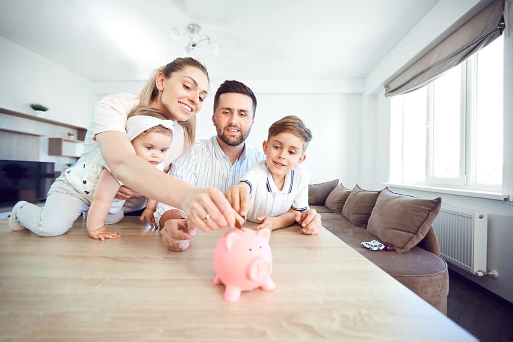 Family putting money into piggy bank