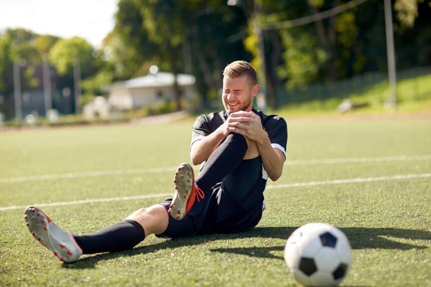 Soccer player gripping leg in pain